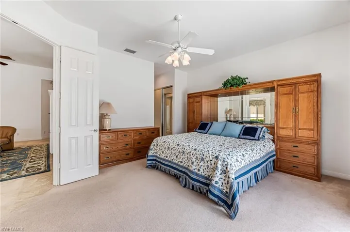 Carpeted bedroom with a closet and ceiling fan