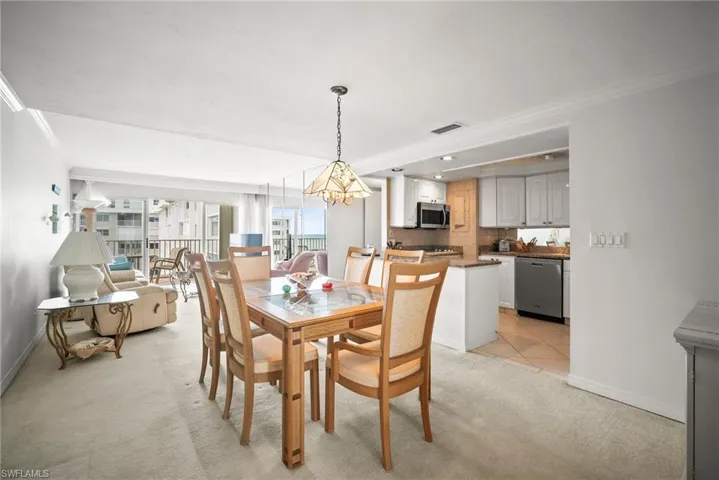 Dining area featuring crown molding and light carpet