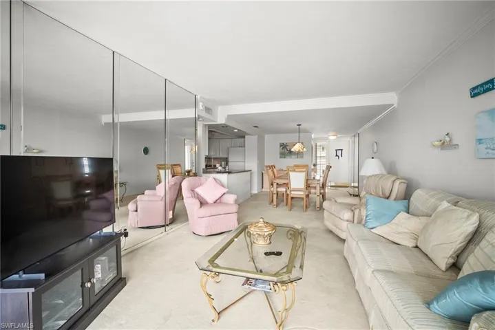 Living room featuring crown molding and light carpet