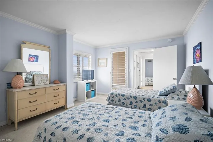 Bedroom with light colored carpet and crown molding