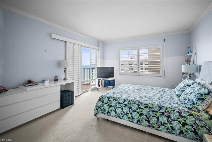 Bedroom with light carpet and ornamental molding