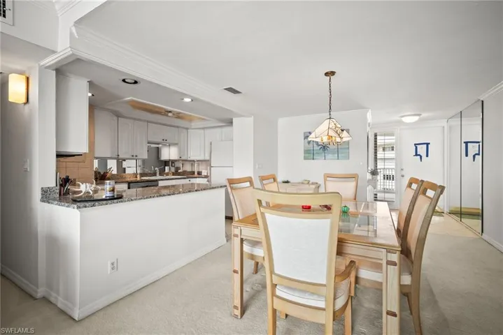 Dining space with crown molding, light colored carpet, a chandelier, and recessed lighting