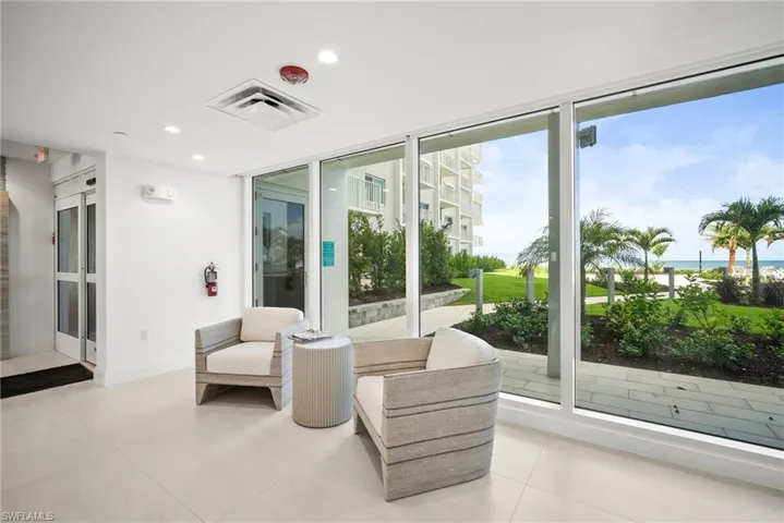 Living area featuring a water view, floor to ceiling windows, light tile patterned flooring, and recessed lighting