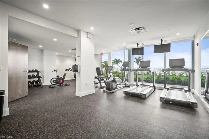 Exercise room with plenty of natural light, floor to ceiling windows, and recessed lighting