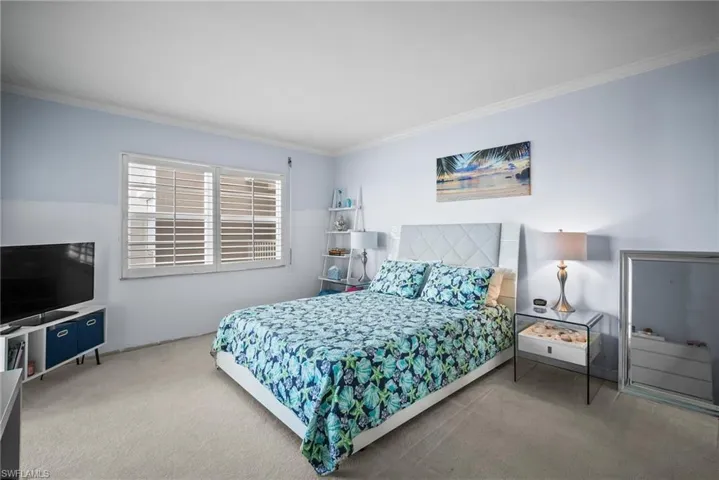 Carpeted bedroom with crown molding