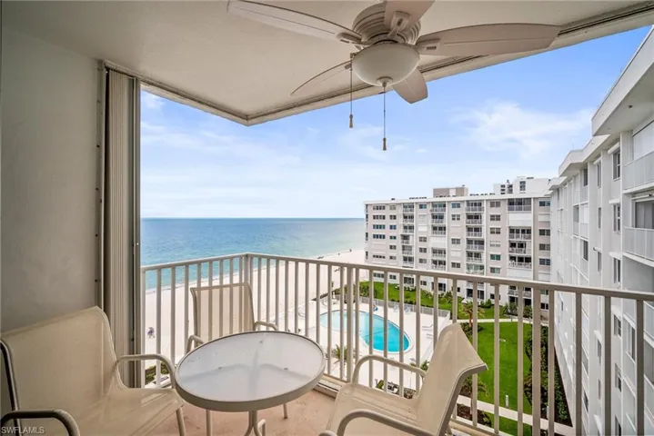 Balcony with a water view, view of pool, and a ceiling fan