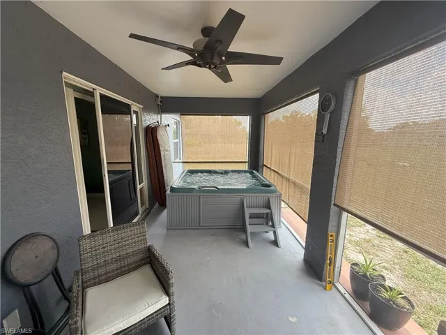 sunroom with a jacuzzi and a ceiling fan