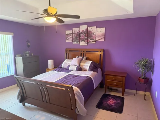 Tiled bedroom with baseboards and ceiling fan