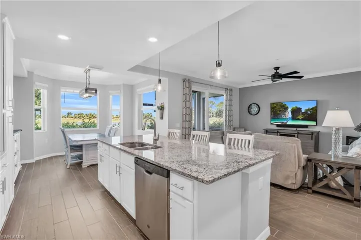Kitchen featuring dishwasher,white cabinetry, and an island with sink