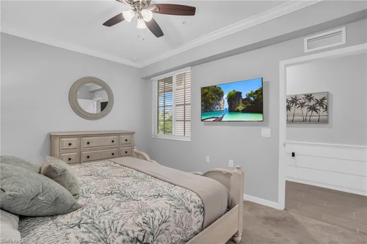 Bedroom with ceiling fan and crown molding
