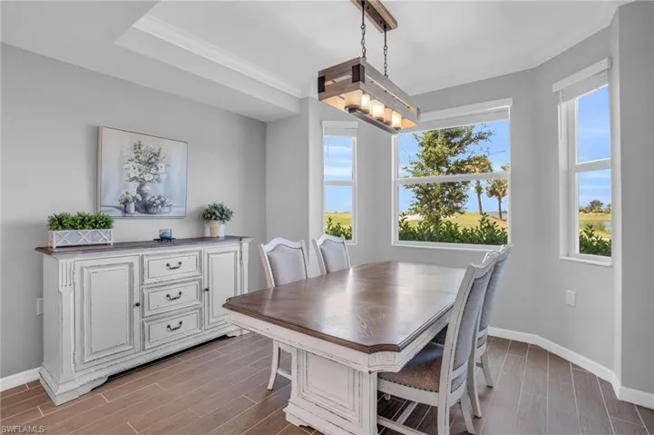 Dining area with a raised ceiling, crown molding