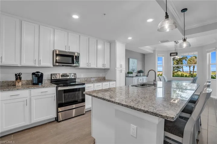 Kitchen with sink, white cabinets, a center island with sink, and stainless steel appliances