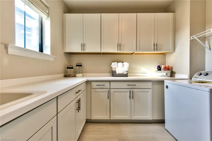 Washroom featuring washer / dryer and cabinet space