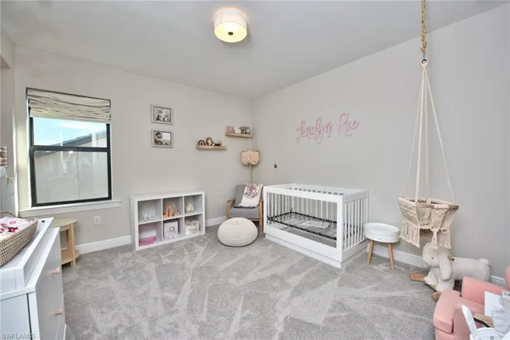 Bedroom with carpet and a nursery area