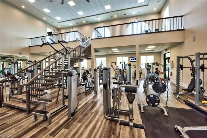 Gym with a high ceiling and wood finished floors