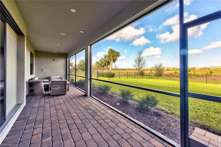 Unfurnished sunroom featuring a textured wall, brick floors, recessed lighting, and a view of rural / pastoral area