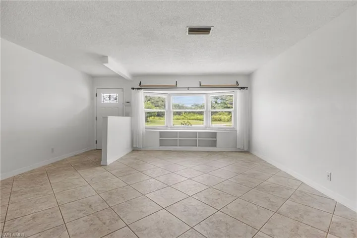 Unfurnished room featuring a textured ceiling and light tile patterned floors