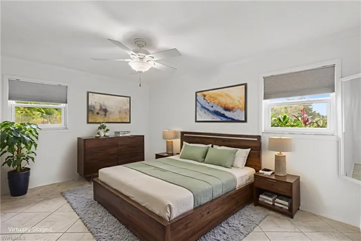 Bedroom with crown molding, ceiling fan, and light tile patterned flooring