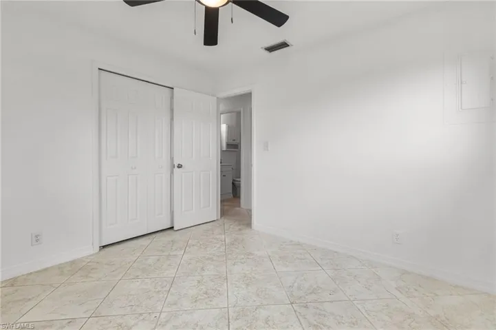 Unfurnished bedroom featuring a closet, a ceiling fan, and tile patterned flooring