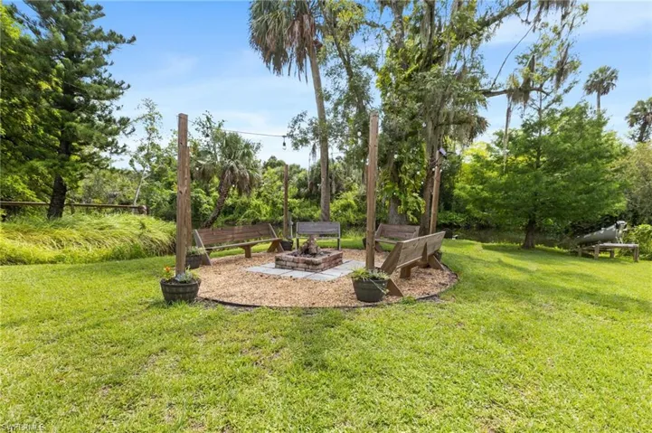 View of green lawn featuring an outdoor fire pit