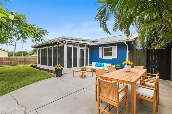 Back of house featuring a sunroom, a patio, a fenced backyard, a metal roof, and an outdoor hangout area