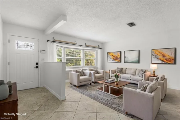 Living room featuring a textured ceiling and light tile patterned flooring
