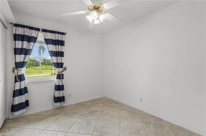 Empty room featuring baseboards and a ceiling fan