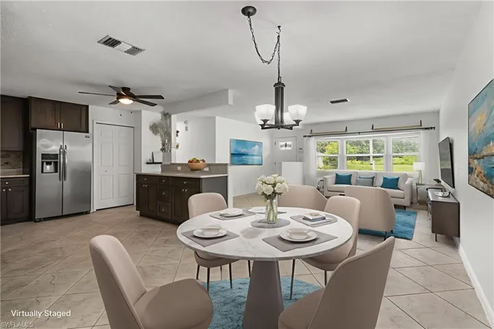 Dining area with a chandelier, a ceiling fan, and light marble finish floors