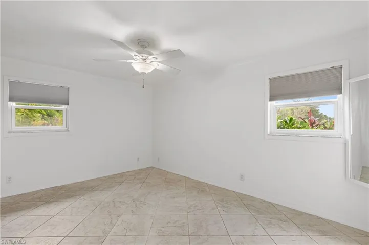 Unfurnished room with healthy amount of natural light, ornamental molding, and ceiling fan