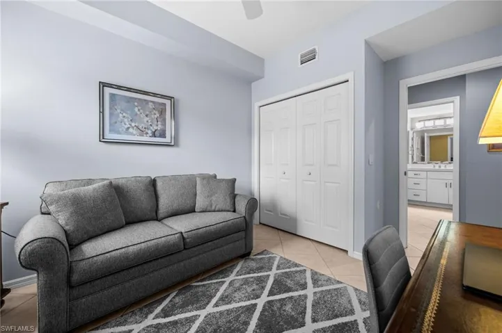 Living room with light tile patterned floors and ceiling fan