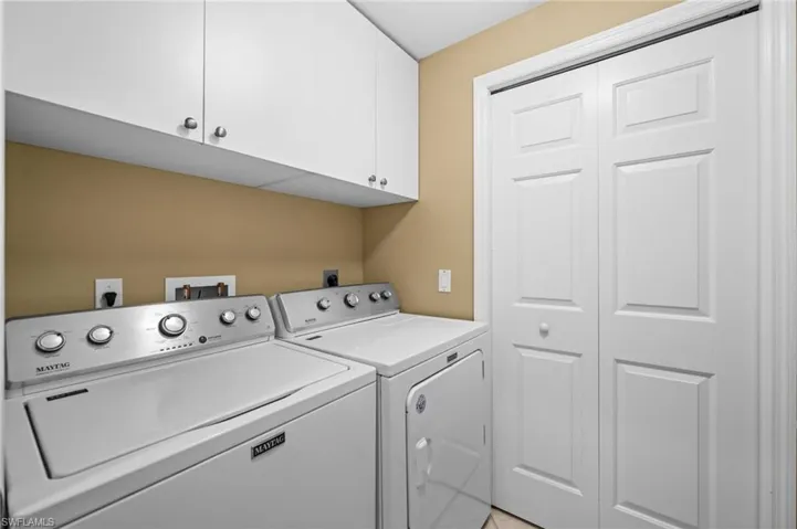 Washroom featuring washer and clothes dryer and cabinet space