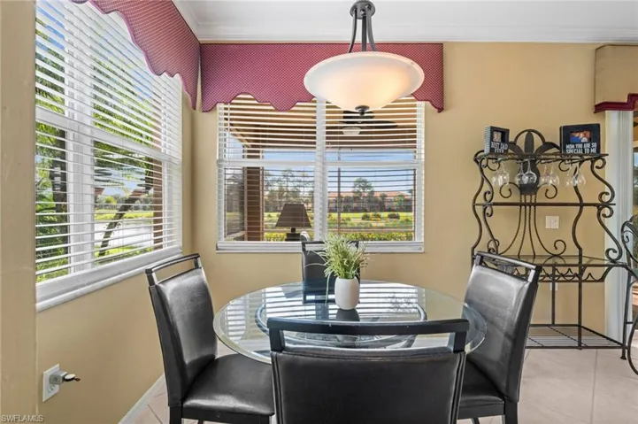 Dining space featuring healthy amount of natural light, light tile patterned floors, and crown molding