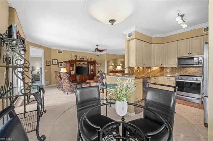 Dining room featuring crown molding, light tile patterned floors, and ceiling fan