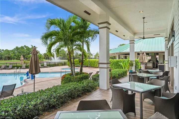 View of patio with outdoor dining space and a community pool