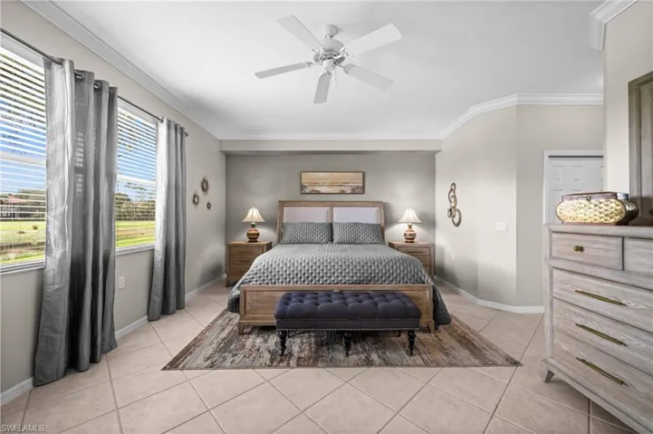 Bedroom featuring crown molding, light tile patterned flooring, and a ceiling fan