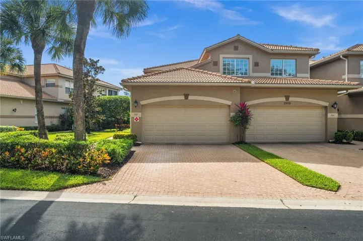 View of front of home with stucco siding, decorative driveway, a garage, and a tiled roof