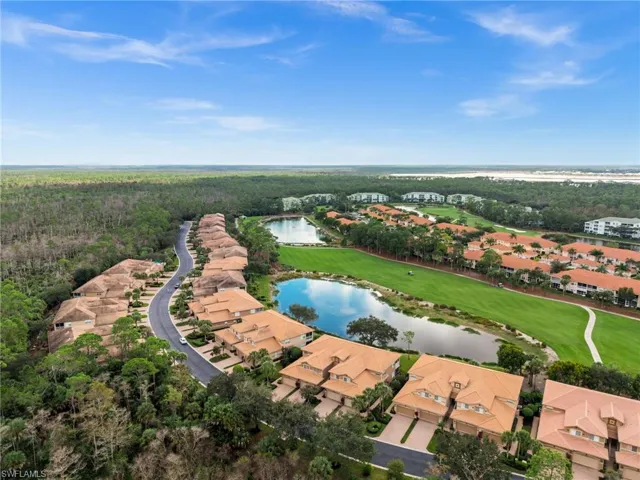Aerial view of residential area with a nearby body of water and a golf club