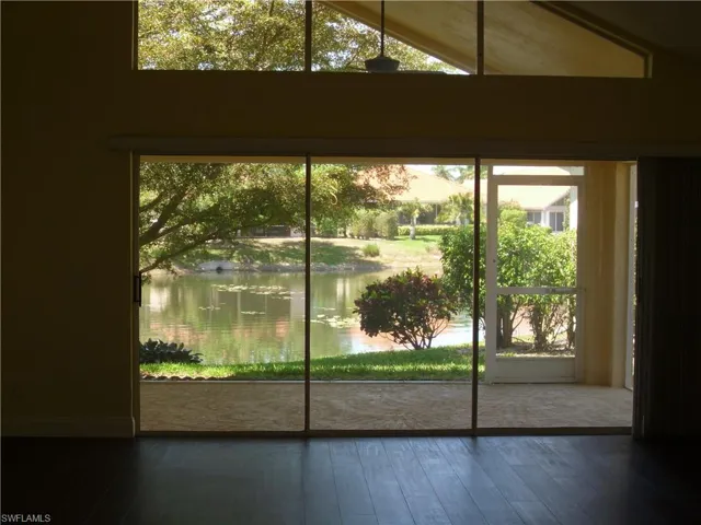 Doorway featuring hardwood / wood-style flooring, a water view, and vaulted ceiling
