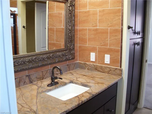 Bathroom featuring vanity and backsplash
