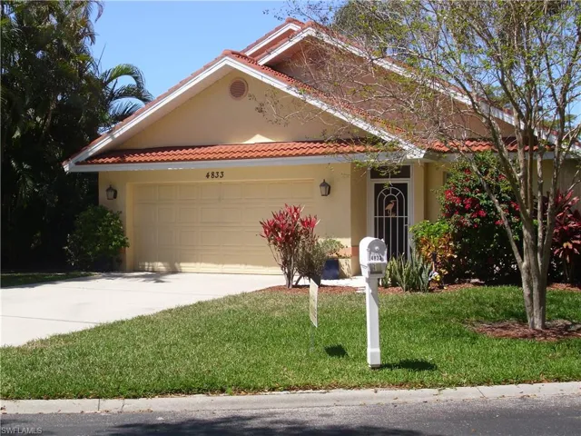 View of front of home featuring an attached garage, a front lawn, concrete driveway, and stucco siding