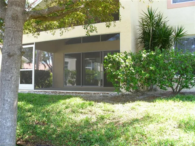 Rear view of property featuring stucco siding and a sunroom