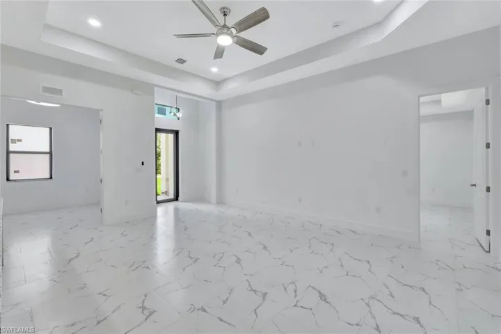 Unfurnished room featuring a tray ceiling, ceiling fan, and recessed lighting
