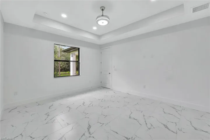 Unfurnished room with a raised ceiling and recessed lighting