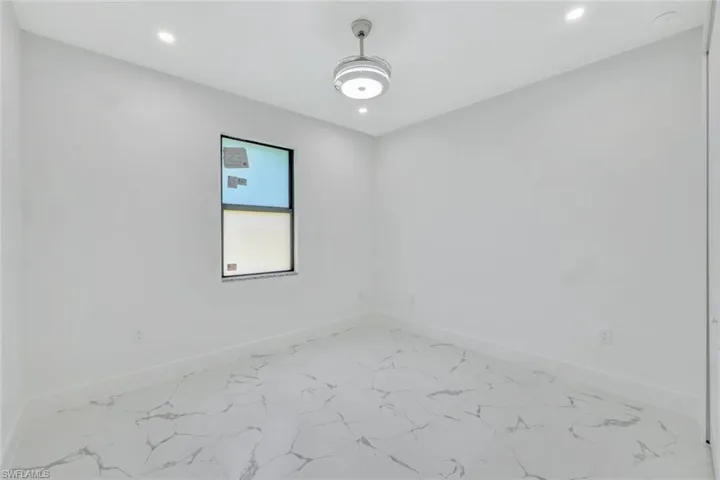 Unfurnished room featuring recessed lighting and marble look tile flooring