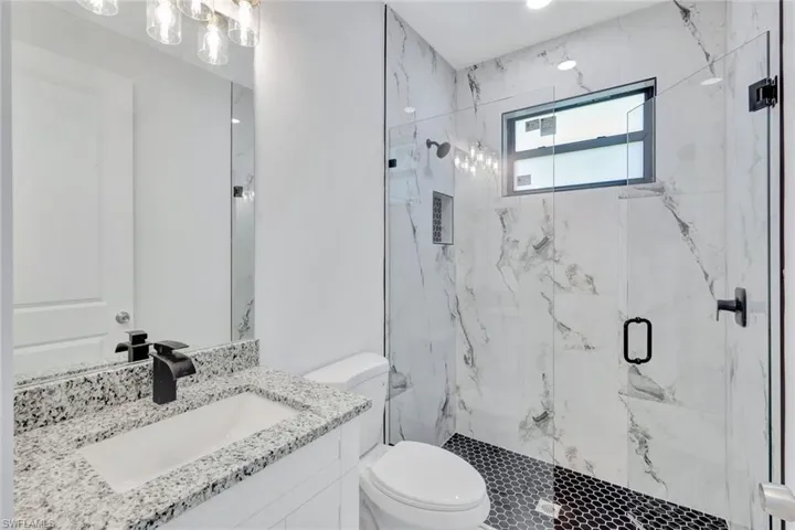 Full bathroom with a marble finish shower and vanity