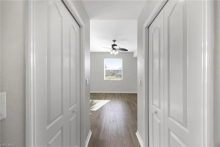 Hallway with baseboards and dark wood-type flooring