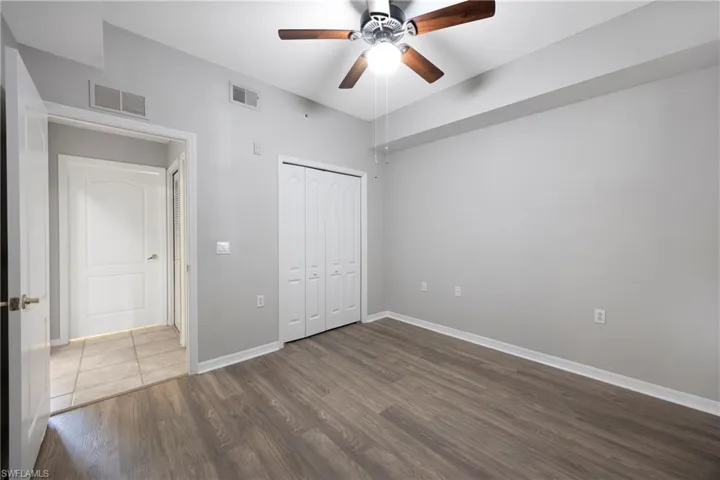 Unfurnished bedroom featuring wood finished floors, a ceiling fan, and a closet