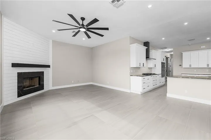 Family room with a fireplace and a ceiling fan