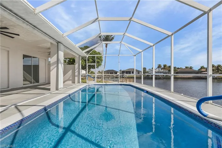 Swimming pool featuring a lanai, screened enclosure, and a water view