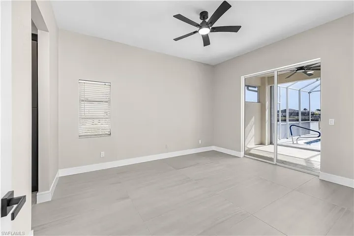 Primary bedroom with a ceiling fan and a slider to the lanai